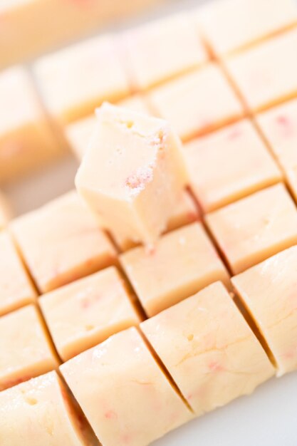 Cutting candy cane fudge into small cubes.