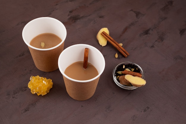 Нарезка чая или мумбаи нарезка чая - популярного индийского уличного чая. сваренное молоко и заварка с имбирем и специями. вкусный напиток из придорожного кафе в бумажных стаканчиках.
