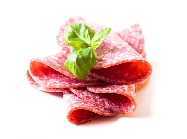 Cutting cold salami slices close up isolated on white