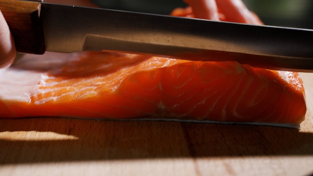 Cutting fish on slices for cooking sushi