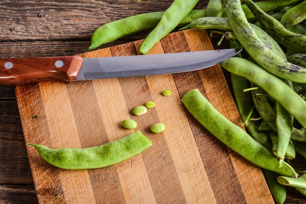 Cutting of green beans pods on a chopping board