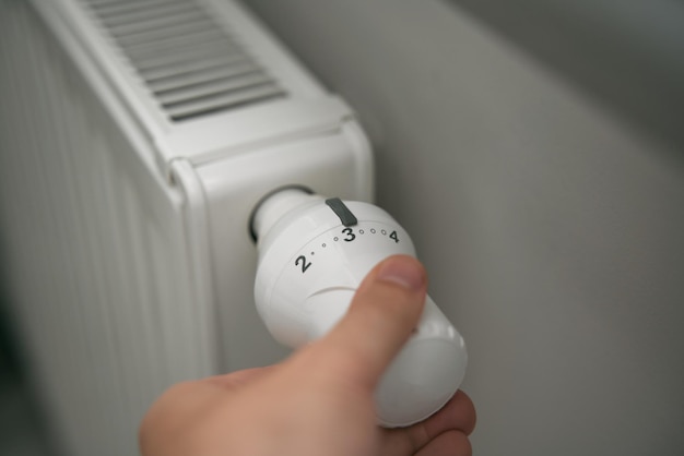 エネルギー危機時の家庭の暖房費の削減 ミニマルなインテリアの暖房用サーモスタットのクローズアップ