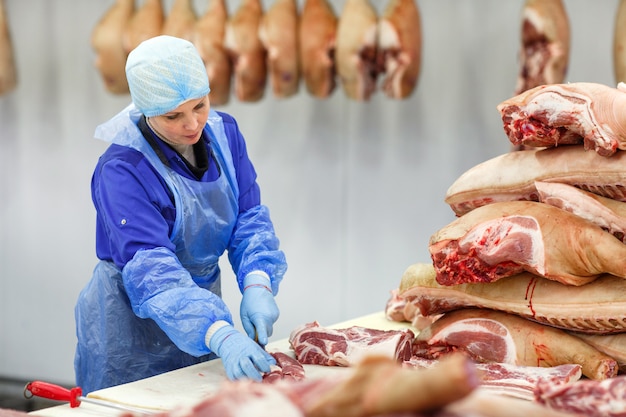 Cutting meat in slaughterhouse .