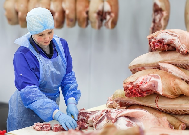 Cutting meat in slaughterhouse .