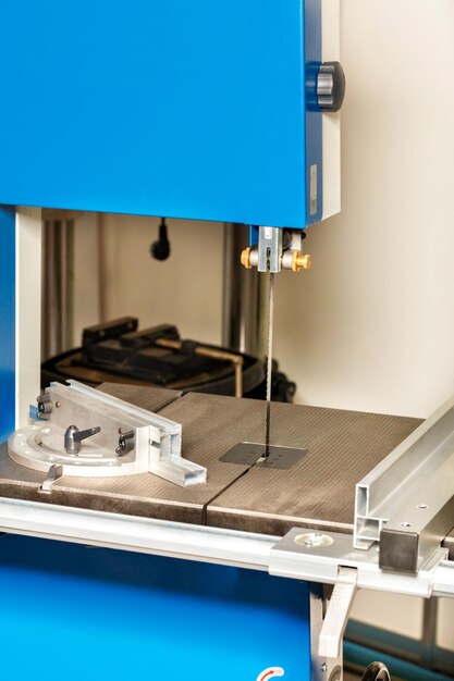 The cutting part of the band saw with adjustable guide rails for precise material processing close-up vertical image copy space precision