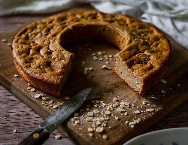 Cutting a piece of healthy sponge cake on a wooden board