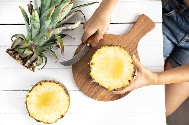 Photo cutting a pineapple opening a piece of pineapple tropical fruit top view