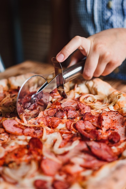 Tagliare la pizza a fette con un coltello speciale