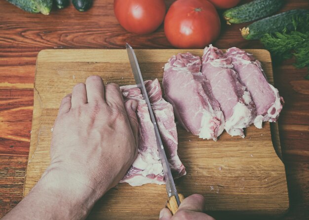 Cutting a pork fillet with a kitchen knife