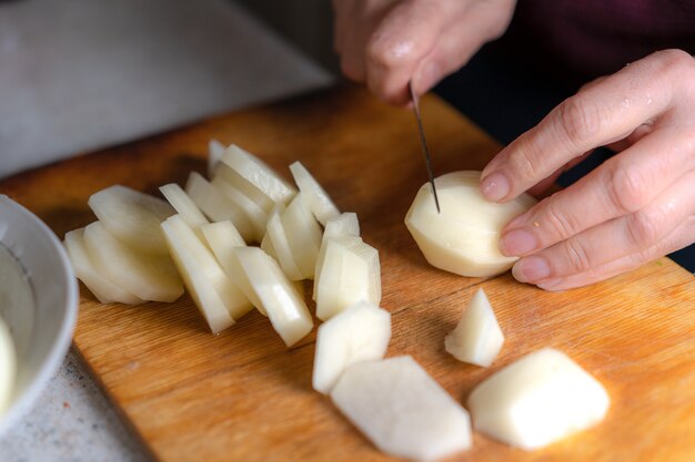 Foto tagliare le patate sul tagliere