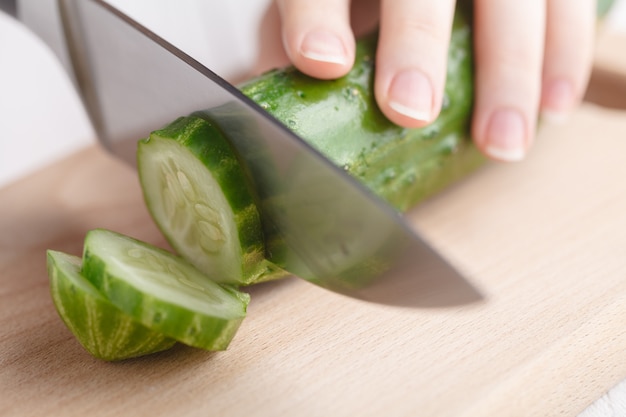 Cutting raw green cucumber