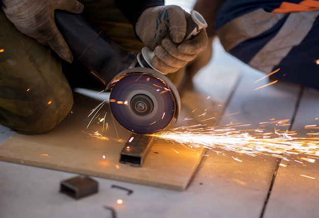 Cutting rectangular metal pipe with angle grinder.