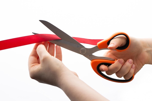 Cutting a red ribbon with scissors on a white background Opening procedure inauguration new project