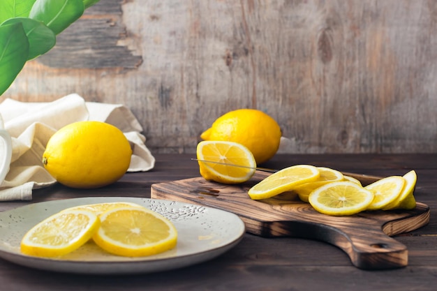 Taglio di limoni maturi su un tagliere di legno e pezzi su un piatto sul tavolo. nutrizione biologica, fonte di vitamine.