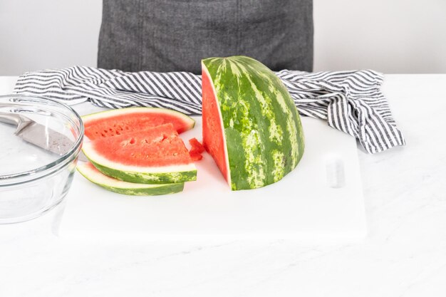 Cutting riped red watermelon to prepare frozen watermelon margarita