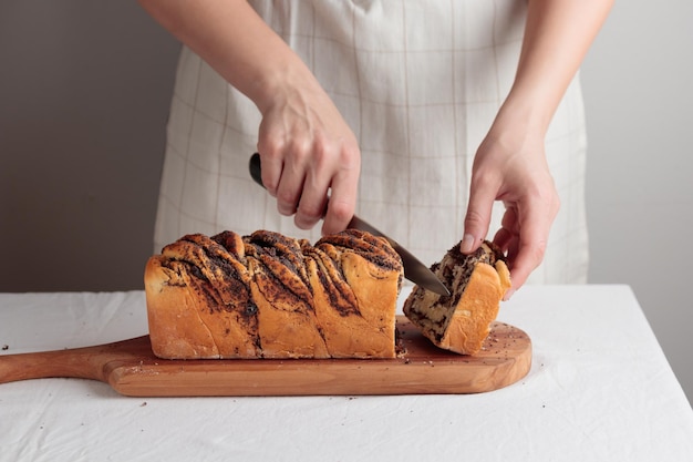 Cutting swirl homemade bread with poppy seeds