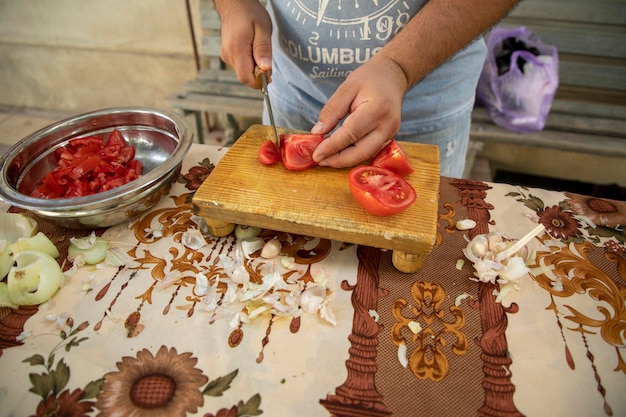 A cutting the tomato in a small parts at 90 degrees