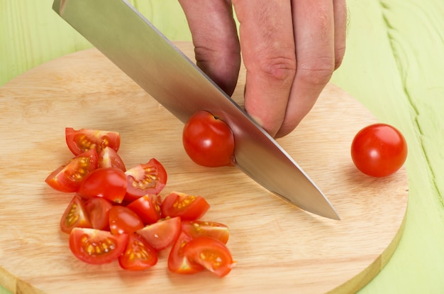 Cutting the vegetables with a kitchen knife on the board