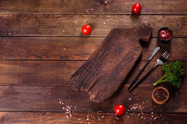 Cutting wooden board as well as vegetables and a special dark table. Preparation for food production