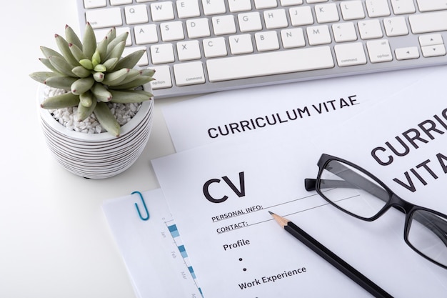 CV, curriculum vitae with keyboard on whtie desk