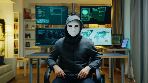 Cyber criminal wearing a white mask using augmented reality to steal secret information.