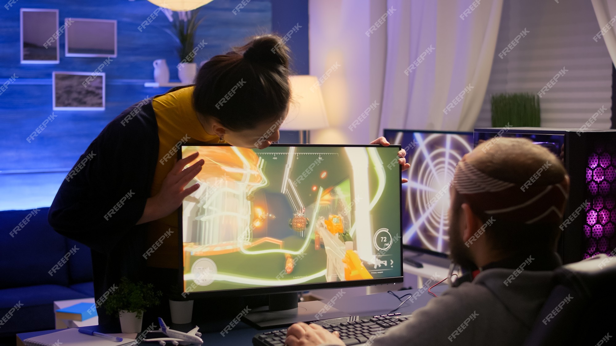 Man gamer teaching his girlfriend playing space shooter video game on RGB  powerful personal computer. Pro cyber woman with headset performing video  games streaming from home during online tournament Stock Photo 