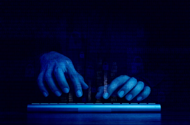 Cyberaanval en internetcriminaliteit hacken en malware concepten Digitale binaire code gegevensnummers en veilige vergrendelingspictogrammen op hackerhanden die met toetsenbordcomputer werken op donkerblauwe toonachtergrond