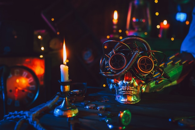 Cyberpunk atmosphere. Skull in steampunk glasses on a table with mechanisms with neon colored light