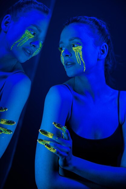 Cyberpunk Girl met gestileerde make-up in het licht van neonlampen