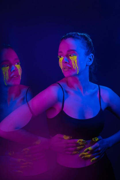 Cyberpunk Girl met gestileerde make-up in het licht van neonlampen