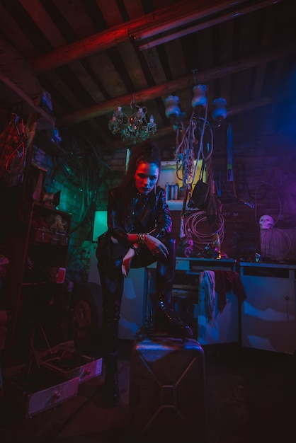 Cyberpunk girl in a post-apocalyptic futuristic style in a garage with a neon light. Steampunk Cosplay