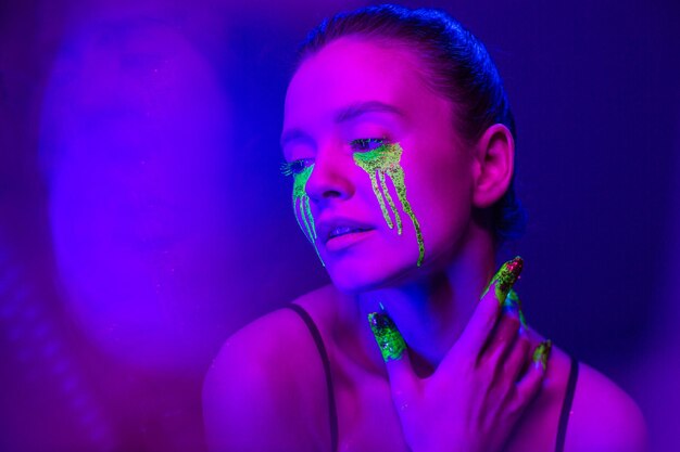 Cyberpunk Girl with stylized makeup in the light of neon lamps