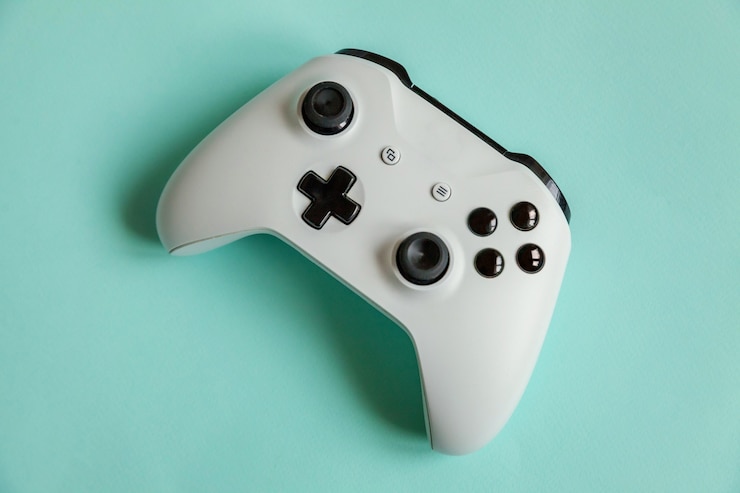 Photo cyberspace symbol. white joystick gamepad, game console isolated on pastel blue colorful trendy surface. computer gaming competition videogame control confrontation concept.