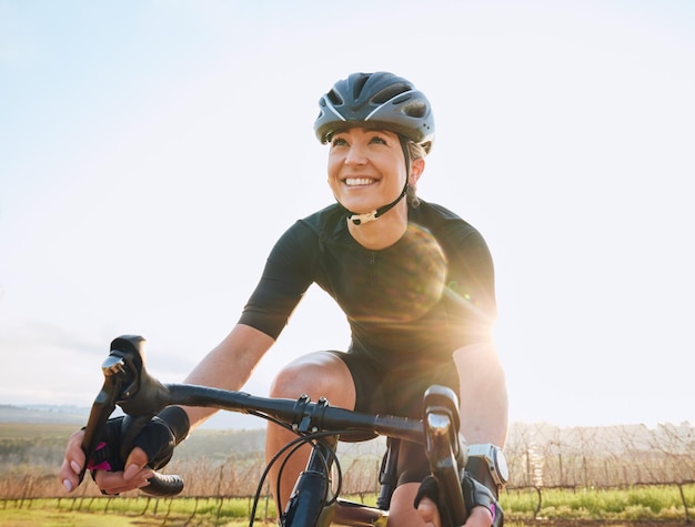 Cycling fitness and happy with woman in park for training workout and cardio health Exercise travel and freedom with female cyclist riding on bike in nature for adventure journey and transport