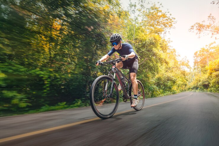 Photo cycling mountain bike 숲이 우거진 도로에서 mtb를 사이클링합니다. 산악 자전거 선수는 산에서 야생의 자연을 봅니다. 익스트림 스포츠와 mtb, 모션 컨셉의 내리막 산악 자전거.