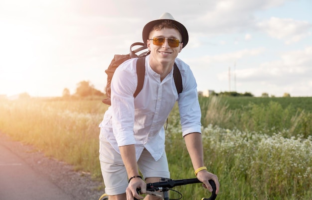 サングラスをかけたサイクリングの若い男と