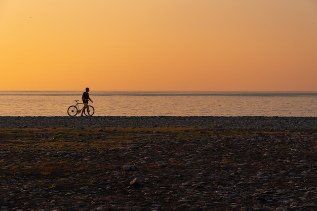 Cyclist on the beach at sunset in Batumi Georgia