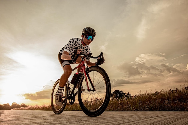 写真 木のトンネルで自転車に乗るサイクリスト