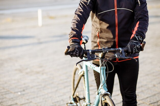 Cyclist in black clothes and helmet trains on a bicycle