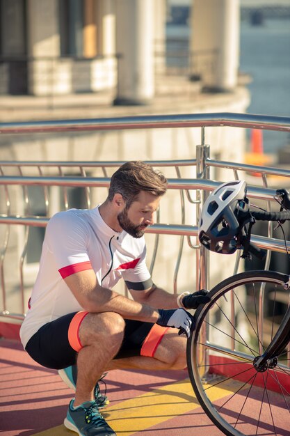 自転車のホイールをチェックするサイクリスト