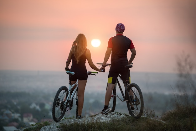 cyclist couple mountain bikes on rock