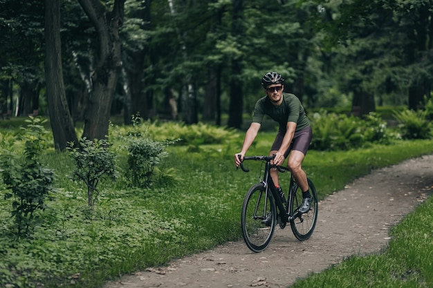 헬멧과 안경을 쓴 자전거 타는 사람은 야외에서 자전거를 타고 있습니다.