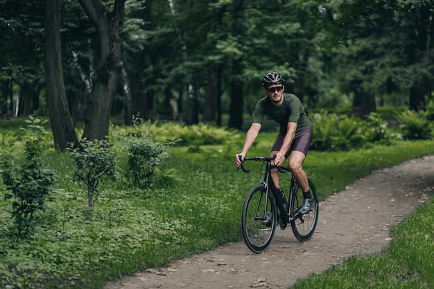 Cyclist in helmet and glasses riding bike outdoors