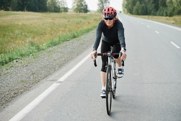 Cyclist in helmet riding a bike on an open road during competition