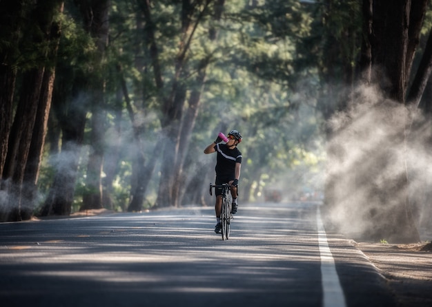 Il ciclista sta bevendo acqua dalla bottiglia sportiva