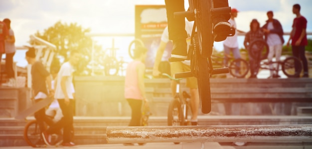 A cyclist jumps over a pipe on a BMX bike. 