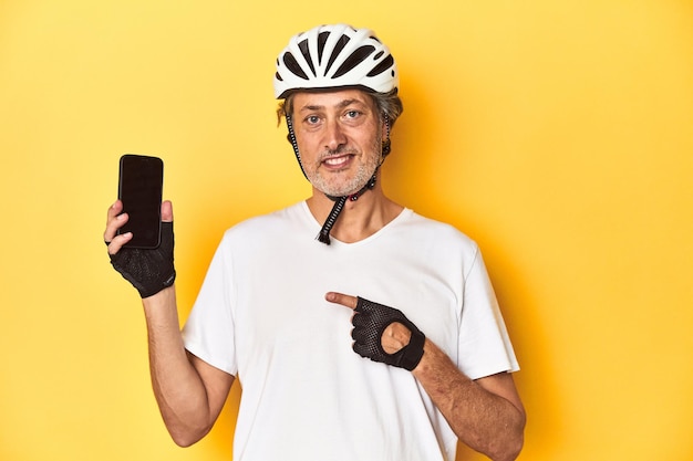 Cyclist man holding a phone representing active lifestyle and technology