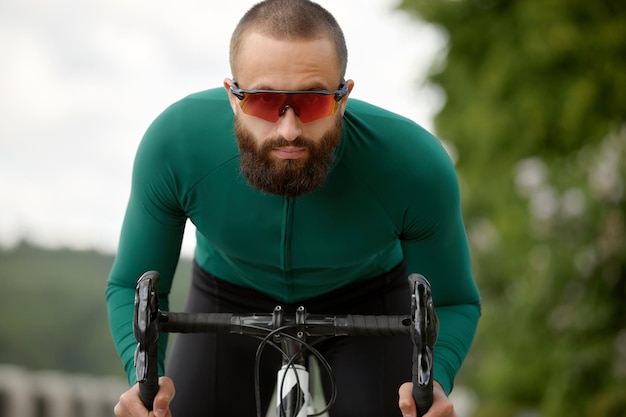 Un ciclista in movimento giro in bicicletta lungo l'argine lungo il fiume