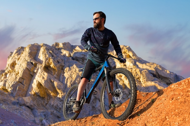 Cyclist in pants and fleece jacket on a hardtail bike with an air suspension fork rides offroad