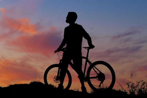 Cyclist in pants and fleece jacket on a modern bike with an air suspension fork rides offroad